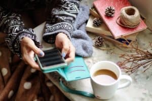 Person on mobile phone with cup of tea